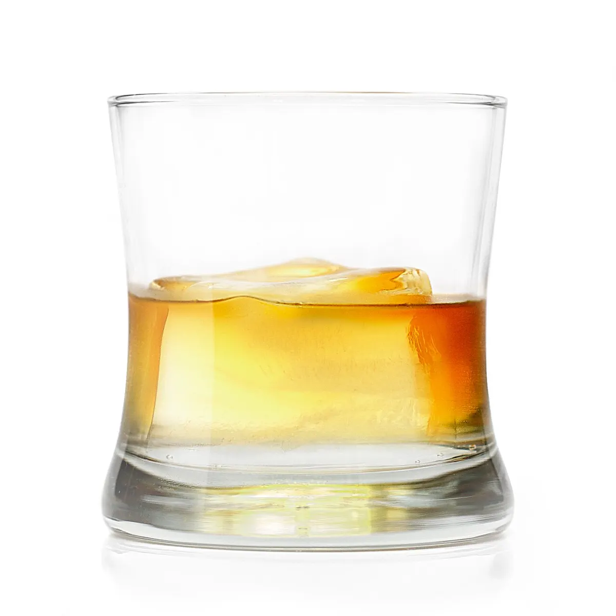 A single large clear ice cube in a rocks glass of whiskey, catching bar light.