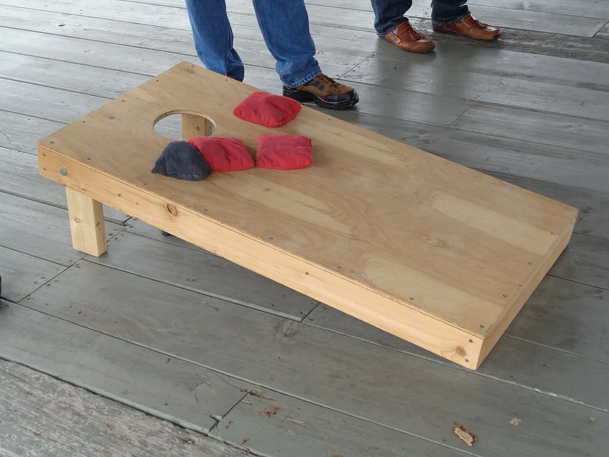Cornhole bags in mid-air toward a regulation board during outdoor play
